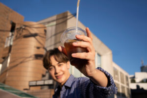 man holding iced tea in the hot weather